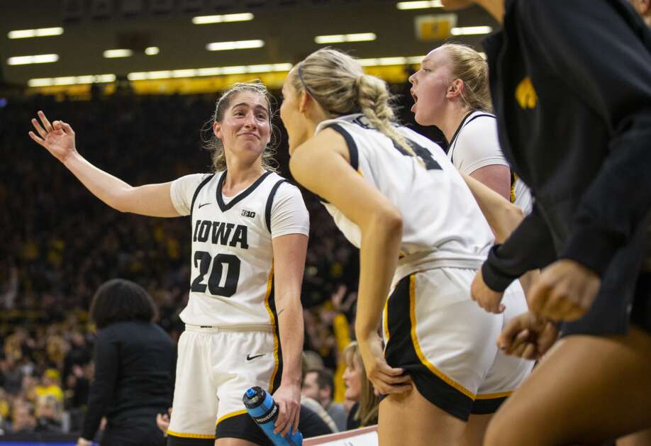 Kate Martin (20) holds out three fingers after Gabbie Marshall (24) made a 3-pointer Saturday against Indiana. (Savannah Blake/The Gazette)