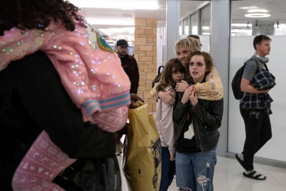 Jacy Bunnell-Ahmed hugs her daughters Sacha (left), 10, and Scarlett, 13, on Tuesday, May 2, 2023, at the Eastern Iowa Airport in Cedar Rapids, Iowa. Ahmed was stranded in Sudan for nearly two weeks as the country’s ongoing civil war damaged the Khartoum airport, preventing flights from leaving the country. After fleeing to Egypt, Ahmed was able to return to the United States. (Geoff Stellfox/The Gazette)