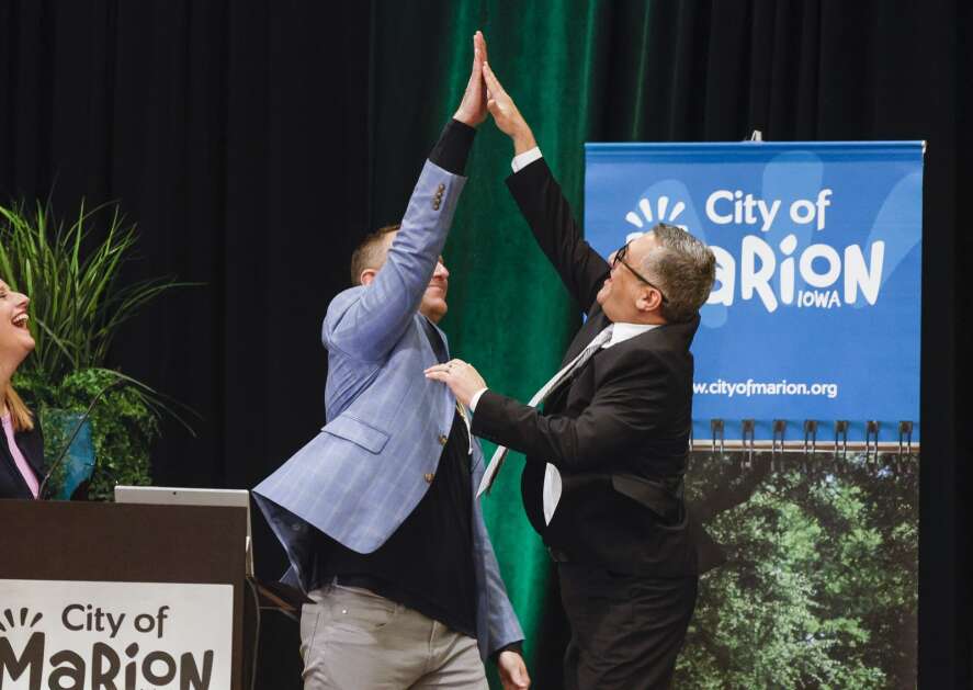 Marion Mayor Nick AbouAssaly (right) leaps to give city manager Ryan Waller a high five as AbouAssaly is introduced for the State of the City address during a luncheon at the Radisson Hotel Cedar Rapids on Tuesday. (Jim Slosiarek/The Gazette)