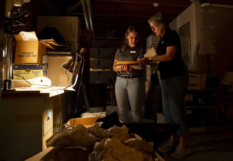 Kristen Smart, owner of Designing Moves (right), and intern Ally Garringer check out items in a box at a client's home in Iowa City on August 16.  (Savannah Blake/The Gazette)
