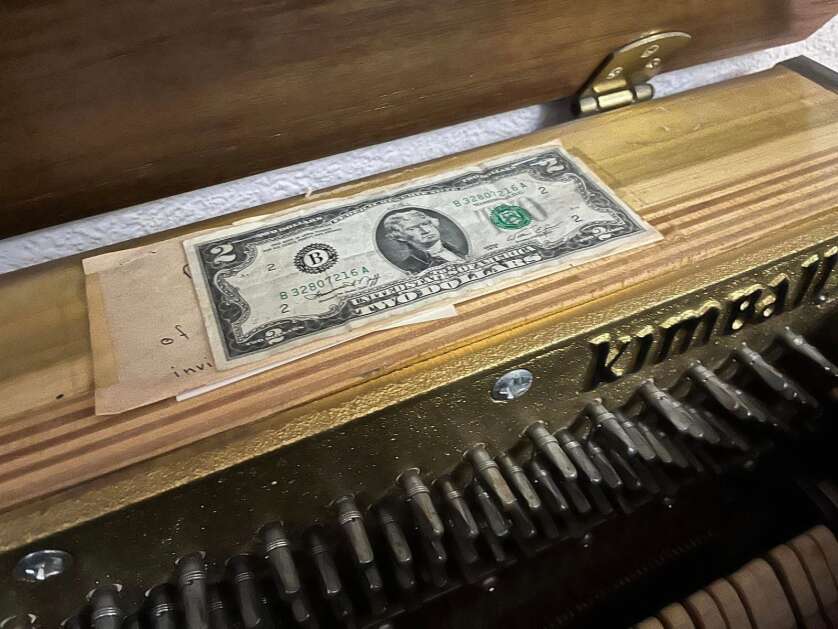 Christina Farrell of Cedar Rapids taped to her piano the $2 bill and note her aunt gave her for her first piano recital, at age 7 in Queens, N.Y. The caveat was that Farrell couldn't spend it until she made her Carnegie Hall debut. She spent the money on two $1-stickers at the famed New York City venue, after performing there with Chorale Midwest on March 13, 2023. (Courtesy of Christina Farrell)