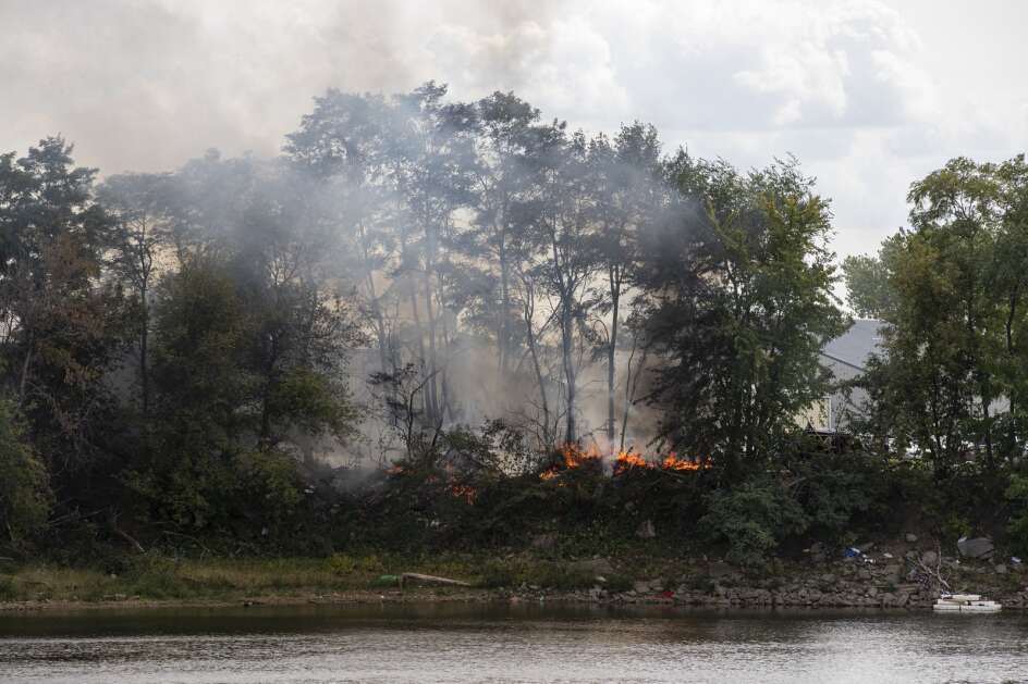 Smoke rises from a fire in a homeless encampment near the Iowa River south of Highway 6 in Iowa City, Iowa on Wednesday, October 4, 2023. (Nick Rohlman/The Gazette)