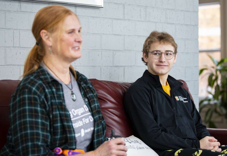 Christopher Turnis smiles Jan. 10 as he watches Kathi Anderson, right, answer interview questions at the Ronald McDonald House in Iowa City. (Savannah Blake/The Gazette)