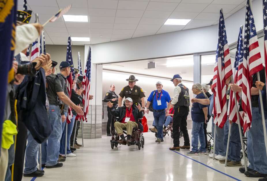 A large crowd cheers as they welcome home Veteran William MacNider after getting off the Honor Flight at the Eastern Iowa Airport in Cedar Rapids, Iowa on Tuesday, April 25, 2023. (Savannah Blake/The Gazette)