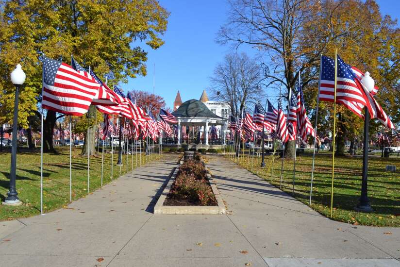 Volunteers, city staff and students put up flags in Fairfield’s Central Park