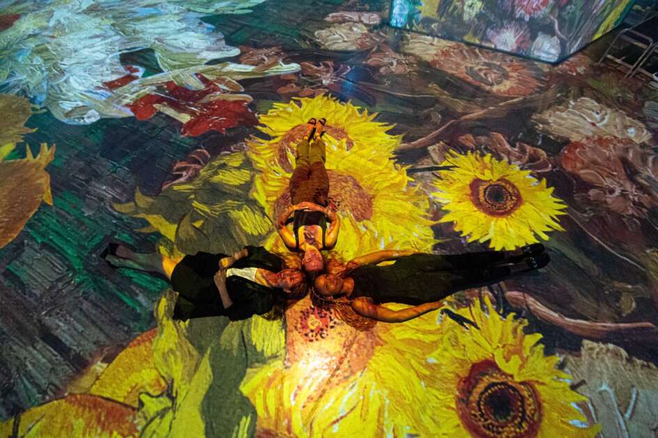 Visitors need not stay on their feet to explore "Beyond Van Gogh: The Immersive Experience." Lying down among the sunflowers is perfectly acceptable. (Paquin Entertainment Group)