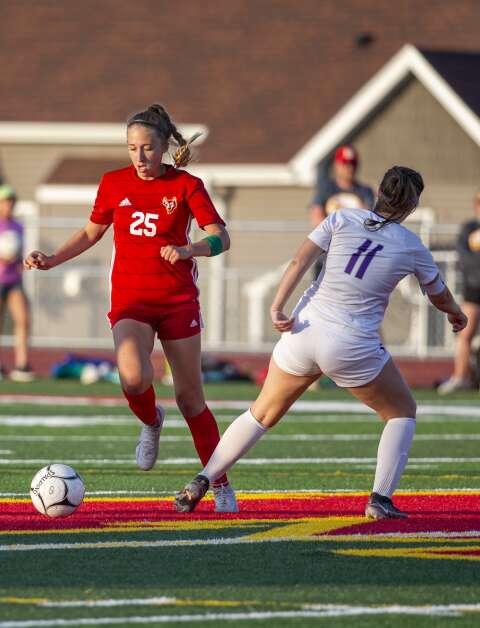Marion midfielder Selah Hill-Dale (25) dribbles the ball down the field with pressure from Iowa City Liberty midfielder Maya Marquardt (11) in the first half of the game at Marion High School in Marion, Iowa on Thursday, May 25, 2023. (Savannah Blake/The Gazette)
