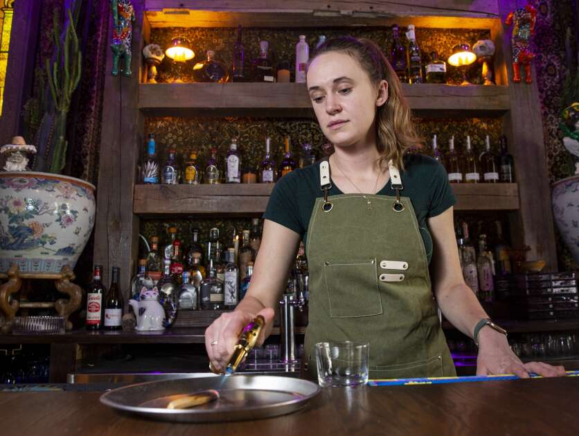Jaime Jackson, food and beverage director for Fun Not Fancy Restaurant Group, smokes Palo Santo for the Iowaxacan Old Fashioned cocktail at Taco Gato on April 12. (Savannah Blake/The Gazette)