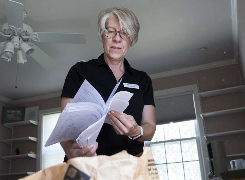 Christine Smart, owner of Designing Moves, sorts documents that will be shredded for an Iowa City client on August 16.  (Savannah Blake/The Gazette)