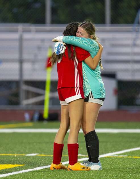 Marion goalkeeper Ashlen Hall (00) becomes emotional as she hugs her teammate after the Wolves defeated the Lightning to qualify for state at Marion High School in Marion, Iowa on Thursday, May 25, 2023. (Savannah Blake/The Gazette)