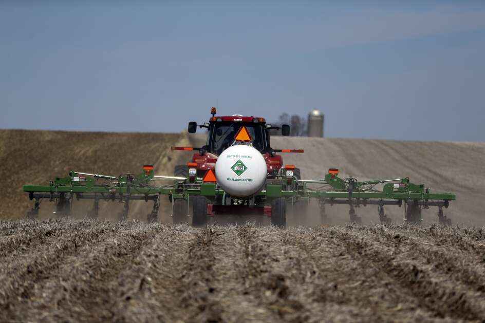 In this April 9, 2014 photo, farmer Craig Boot pulls a tank of anhydrous ammonia behind his tractor before injecting the chemical into the soil in preparation for spring planting in a cornfield near the Marion and Mahaska County line outside Pella. (AP Photo/The Des Moines Register, Charlie Litchfield)