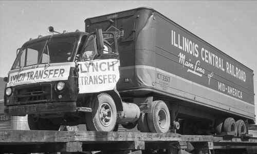 Trucks filled with cargo ‘piggybacked’ on rail cars in 1950s